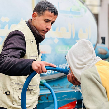 Aid worker helping with water distribution